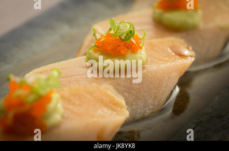 La vibrante Tonno bianco Tonno sashimi serviti sulla piastra con wasabi, Masago e cipolla verde. Foto Stock