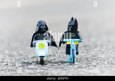 Lego Batman adn Darth Vader cavalcare lungo con noleggio biciclette e scooter. Foto Stock