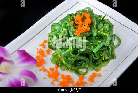 Giapponese insalata di alghe marine top con uova e lattimi di pesce impostato sulla piastra bianca con studio di illuminazione. Foto Stock
