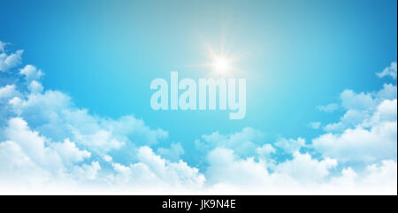 La luce del sole splende alto nel cielo blu, al di sopra delle nuvole bianche Foto Stock