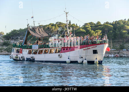 Imbarcazione da diporto con allegro turisti entra nel porto di Makarska, Croazia. Foto Stock