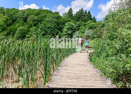 I turisti a piedi lungo le passerelle di legno nel Parco Nazionale dei Laghi di Plitvice, Croazia. Foto Stock