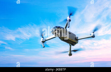 Drone in volo su un cielo blu sullo sfondo Foto Stock