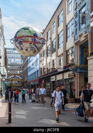 Pedoni in Carnaby Street, Londra, Regno Unito. Grande Globo sospeso con messaggi: Carnaby accoglie favorevolmente il mondo e #LondonIsOpen. Foto Stock