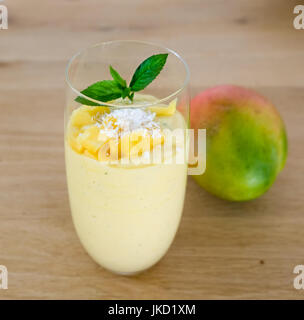 Un bicchiere con un sano mango-smoothie con cocos, lime e menta Foto Stock