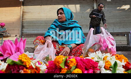 Varanasi, India - 17 dicembre 2012.Donna vendita di fiori su una strada al mattino Foto Stock