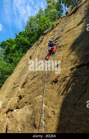 Maschio scalatore rock climbing a Yarncliffe cava, Derbyshire Foto Stock