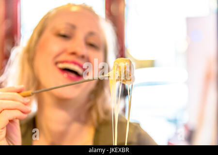 Donna di mangiare la fonduta di formaggio Foto Stock