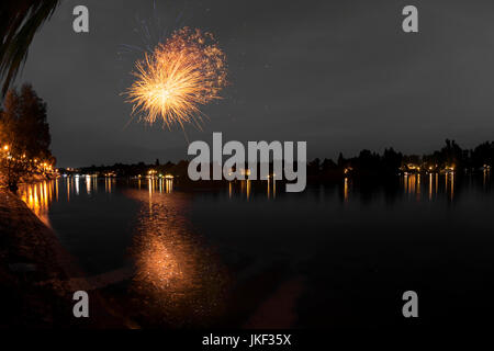 Fuochi d'artificio sul fiume Ticino in una serata estiva con un paesaggio in background Foto Stock