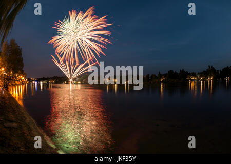 Fuochi d'artificio sul fiume Ticino in una serata estiva con un paesaggio in background Foto Stock