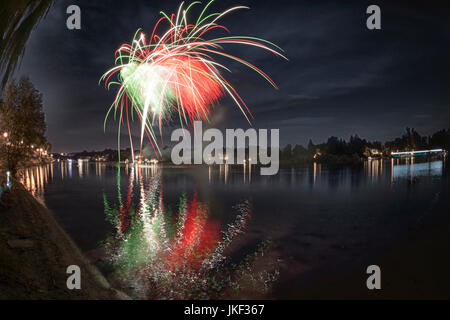 Fuochi d'artificio sul fiume Ticino in una serata estiva con un paesaggio in background Foto Stock