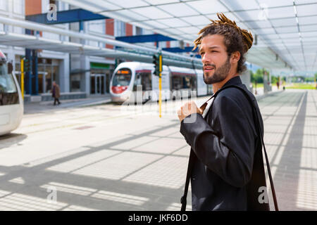 L'Italia, Firenze, Casual giovane imprenditore con dreadlocks in attesa presso la stazione della metropolitana Foto Stock