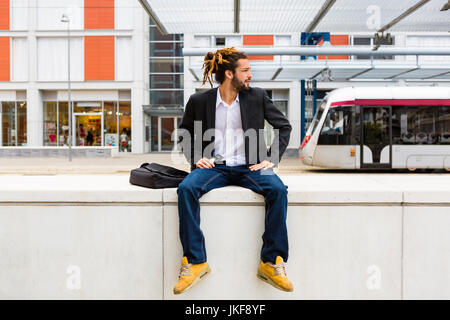 L'Italia, Firenze, Casual giovane imprenditore con dreadlocks in una città contemporanea Foto Stock