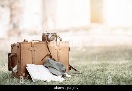 Borsa vintage e attrezzature traveler su erba, vecchio tempio di sfondo e tono vintage Foto Stock