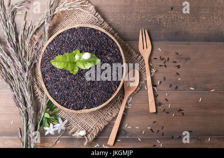 Riso al gelsomino beery nel cestello di bambù sul legno scuro sfondo, cibo sano e concetto di dieta Foto Stock