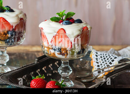 Fragola insalata di frutta con miele yogurt in ciotole in vetro guarnito con menta fresca Foto Stock