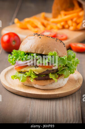 In casa hamburger e patatine fritte su sfondo di legno Foto Stock