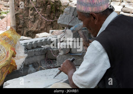 Un anziano scalpellino che è venuto fuori di pensionamento per lavorare sulla ricostruzione post-terremoto Bhaktapur Kathmandu in Nepal Foto Stock