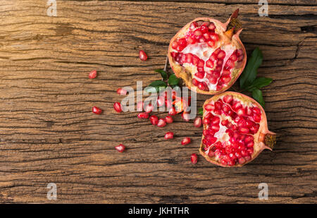 La metà dei frutti di melograno sul vecchio sfondo di legno Foto Stock