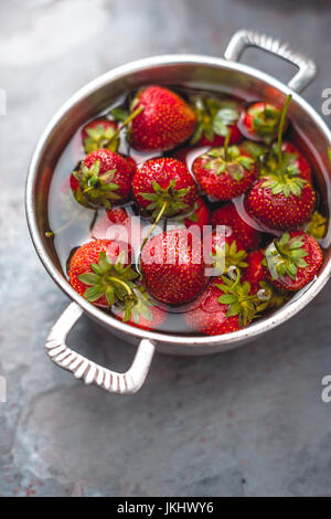 Fragole fresche in una ciotola sulla copia tabella verticale dello spazio Foto Stock