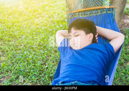 Obesi fat boy dormire sulla culla in posizione di parcheggio Foto Stock