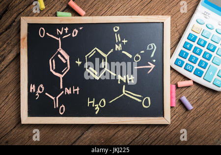 Legame chimico su una lavagna e uno sfondo di legno Foto Stock