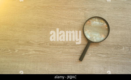 Lente di ingrandimento in laminato grigio Sfondo. Effetto sole Foto Stock