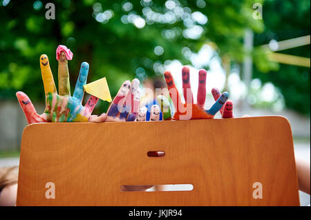 Bambini multicolore di vernici colorato dita sulla natura. Foto Stock