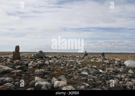 Paesaggio roccioso disseminato di piccoli inuksuit lungo il Canada costa artico Foto Stock