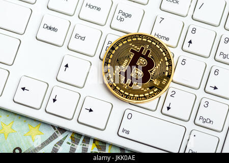 Bitcoin moneta sulla tastiera bianca e denaro Foto Stock