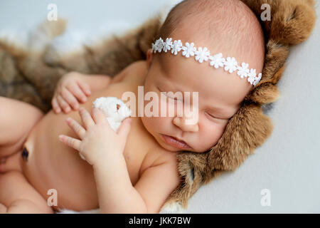 Neonato nella hat dorme con un giocattolo Foto Stock