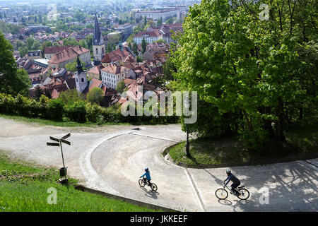 Madre e figlio in bicicletta al castello con vista panoramica sulla città vecchia di Lubiana, Slovenia. Foto Stock