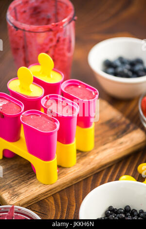 Fare frutti di bosco popsicles a casa da ingredienti freschi Foto Stock