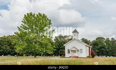 Piccolo centro rurale chiesa bianca e il cimitero su una strada sterrata in rurale Alabama, Stati Uniti d'America. Foto Stock