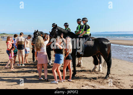 Troon, Ayrshire, Regno Unito. Il 24 luglio, 2017. Più di duemila persone per la maggior parte degli adolescenti, ha visitato la spiaggia di South Beach a Troon in risposta ad un invito aperto, attraverso Facebook a un party in spiaggia e per approfittare del sole calde temperature estive. Dopo un simile Facebook beach party la settimana precedente quando vi è stato diversi arresti per la polizia disturbi la Scozia ha dato molta attenzione per la zona, ma questa volta non ci sono stati arresti e la presenza delle forze di polizia i cavalli hanno dimostrato di essere buoni relazioni pubbliche. Credito: Findlay/Alamy Live News Foto Stock