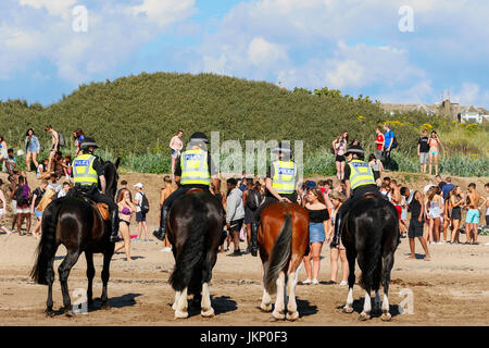 Troon, Ayrshire, Regno Unito. Il 24 luglio, 2017. Più di duemila persone per la maggior parte degli adolescenti, ha visitato la spiaggia di South Beach a Troon in risposta ad un invito aperto, attraverso Facebook a un party in spiaggia e per approfittare del sole calde temperature estive. Dopo un simile Facebook beach party la settimana precedente quando vi è stato diversi arresti per la polizia disturbi la Scozia ha dato molta attenzione per la zona, ma questa volta non ci sono stati arresti e la presenza delle forze di polizia i cavalli hanno dimostrato di essere buoni relazioni pubbliche. Credito: Findlay/Alamy Live News Foto Stock