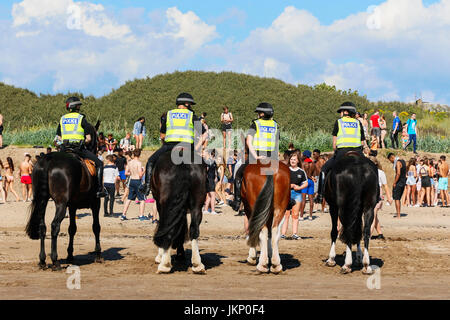 Troon, Ayrshire, Regno Unito. Il 24 luglio, 2017. Più di duemila persone per la maggior parte degli adolescenti, ha visitato la spiaggia di South Beach a Troon in risposta ad un invito aperto, attraverso Facebook a un party in spiaggia e per approfittare del sole calde temperature estive. Dopo un simile Facebook beach party la settimana precedente quando vi è stato diversi arresti per la polizia disturbi la Scozia ha dato molta attenzione per la zona, ma questa volta non ci sono stati arresti e la presenza delle forze di polizia i cavalli hanno dimostrato di essere buoni relazioni pubbliche. Credito: Findlay/Alamy Live News Foto Stock