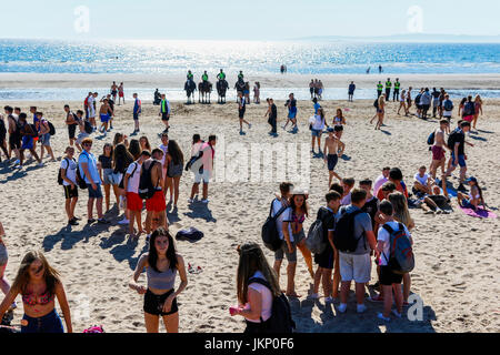Troon, Ayrshire, Regno Unito. Il 24 luglio, 2017. Più di duemila persone per la maggior parte degli adolescenti, ha visitato la spiaggia di South Beach a Troon in risposta ad un invito aperto, attraverso Facebook a un party in spiaggia e per approfittare del sole calde temperature estive. Dopo un simile Facebook beach party la settimana precedente quando vi è stato diversi arresti per la polizia disturbi la Scozia ha dato molta attenzione per la zona, ma questa volta non ci sono stati arresti e la presenza delle forze di polizia i cavalli hanno dimostrato di essere buoni relazioni pubbliche. Credito: Findlay/Alamy Live News Foto Stock