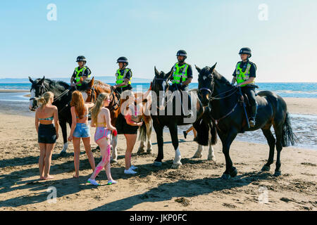 Troon, Ayrshire, Regno Unito. Il 24 luglio, 2017. Più di duemila persone per la maggior parte degli adolescenti, ha visitato la spiaggia di South Beach a Troon in risposta ad un invito aperto, attraverso Facebook a un party in spiaggia e per approfittare del sole calde temperature estive. Dopo un simile Facebook beach party la settimana precedente quando vi è stato diversi arresti per la polizia disturbi la Scozia ha dato molta attenzione per la zona, ma questa volta non ci sono stati arresti e la presenza delle forze di polizia i cavalli hanno dimostrato di essere buoni relazioni pubbliche. Credito: Findlay/Alamy Live News Foto Stock