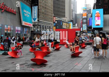 New York, US. Il 24 luglio, 2017. New York, NY, USA. -- 24 luglio, 2017-- i giovani e i giovani di cuore i visitatori a Times Square si fermò un momento di divertimento a mezzogiorno con il Magis Spun sedia. Il montante filate sedie è un affascinante sedia che assomiglia più ad un recipiente scultoreo di un sedile. Ma quando si appoggia sul suo lato, si forma una confortevole sedia funzionale che consente di roccia da lato a lato o girare intorno a. Credito: G. Ronald Lopez /DigiPixsAgain.us/Alamy Live News Foto Stock