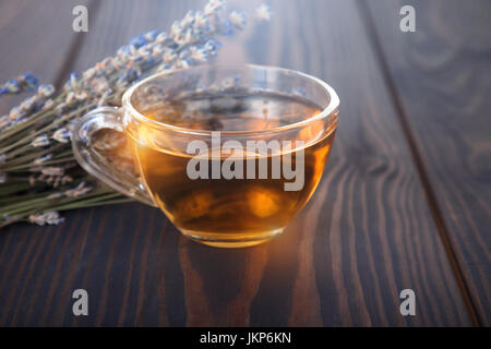 Tazza di tè di lavanda e Lavanda fiori su un tavolo di legno. Foto Stock