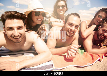 Gruppo di amici a prendere il sole sulla spiaggia Foto Stock