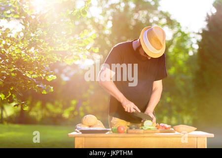 Giovane uomo parigamba preparare cibo per garden grill party, estate barbecue concept Foto Stock