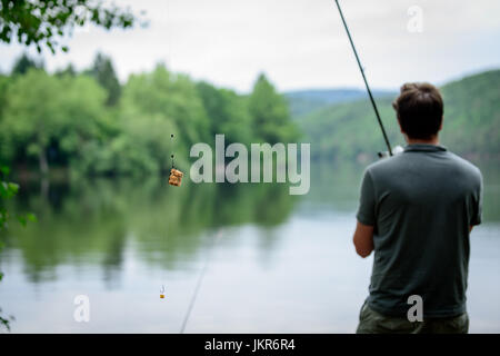 Pescatore in piedi sulle rive del fiume Vltava, pesca concetto getaway Foto Stock