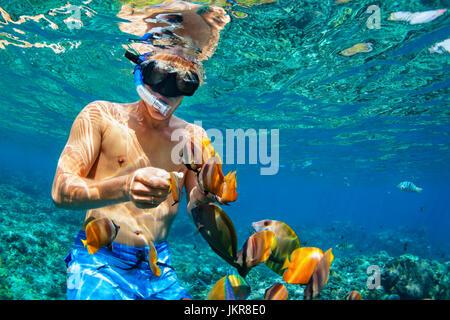 La famiglia felice vacanza - uomo in snorkeling maschera subacquea Immersioni con pesci tropicali in Coral reef piscina sul mare. Lo stile di vita di viaggio, acqua sport avventura Foto Stock