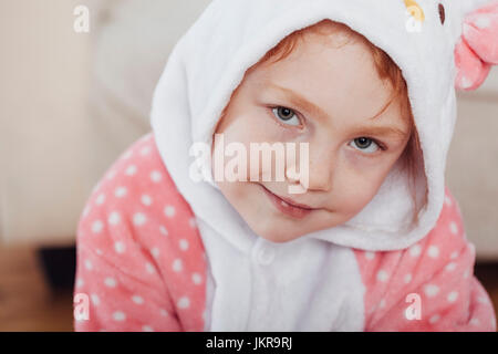 Close-up ritratto della ragazza sorridente indossando maglietta con cappuccio a casa Foto Stock