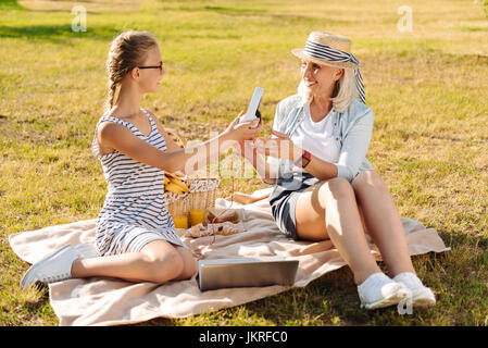Positivo adolescente carina ragazza appoggiata nel parco con sua nonna Foto Stock
