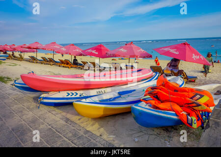 BALI, Indonesia - 11 Marzo 2017: una bella giornata di sole con una fila di unmbrellas rosso e alcune barche sulla sabbia gialla, nella spiaggia di Pantai pandawa, nell isola di Bali, Indonesia Foto Stock