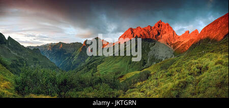 Un tramonto meraviglioso e di post-incandescenza rossa in alta montagna. Foto Stock