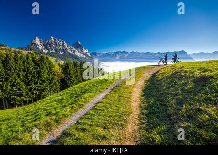 Due biker guardando i picchi di Mythen, il Lago di Lucerna, Rigi e Brunnen città dal Sattel, nella Svizzera centrale. Foto Stock